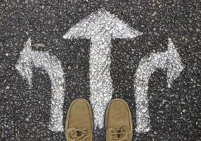 man with mutliple arrows choosing from PhD programme options for application help